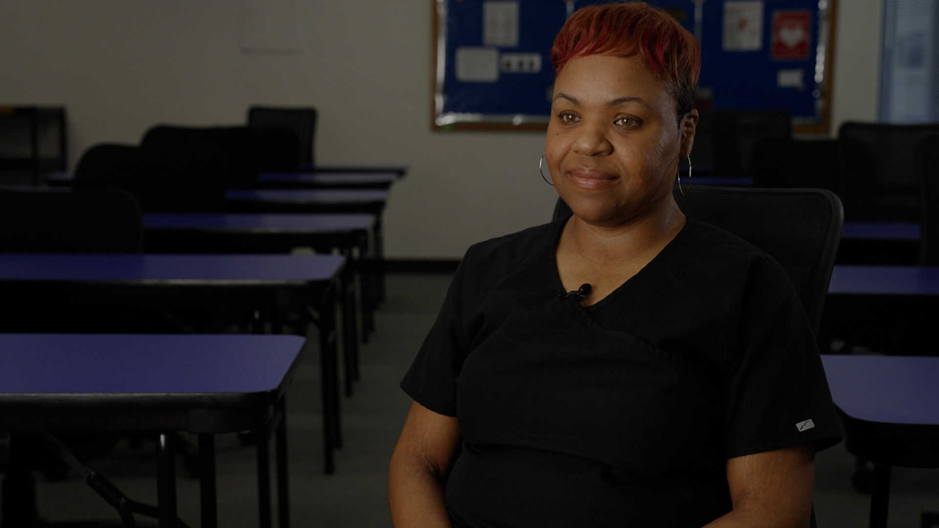 Latifa Brown wears a black shirt while sitting inside a classroom